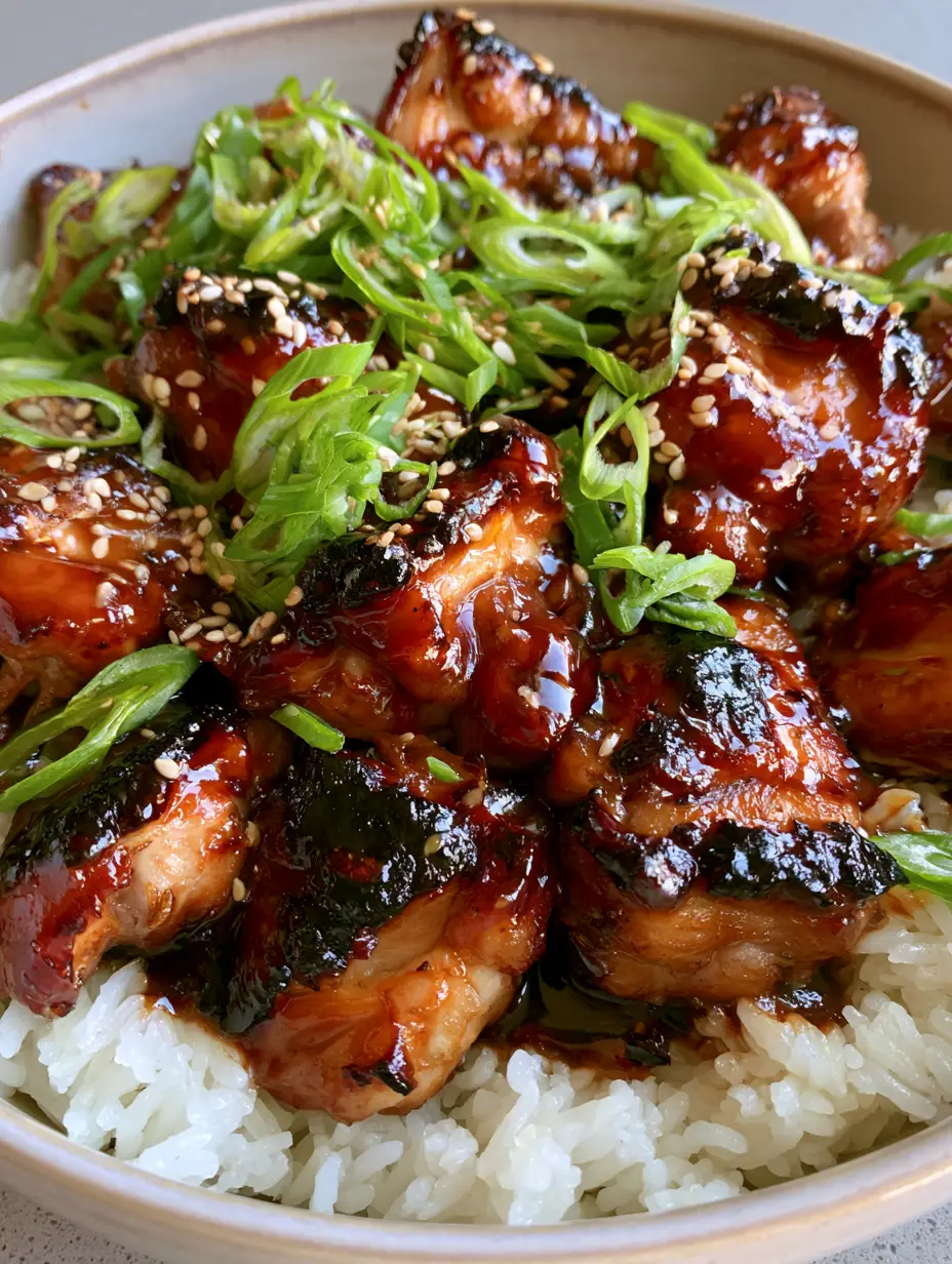 Close up of bite-sized chicken thighs with a thick mahogany bourbon glaze and charred edges. (bourbon chicken recipe)