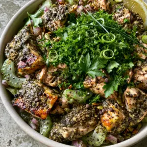 Close up shot showing the texture of the thick herb pesto dressing and seared chicken in the dirty herb chicken salad.