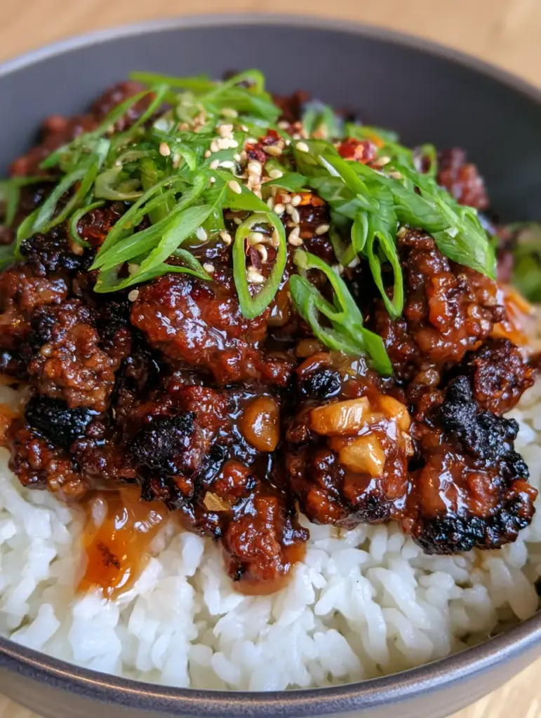 Gourmet honey garlic beef bowl showing the individual grains of jasmine rice and thick amber glaze.